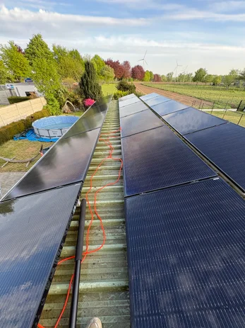 Zonnepanelen na professionele reiniging op een woning met tuin en zwembad